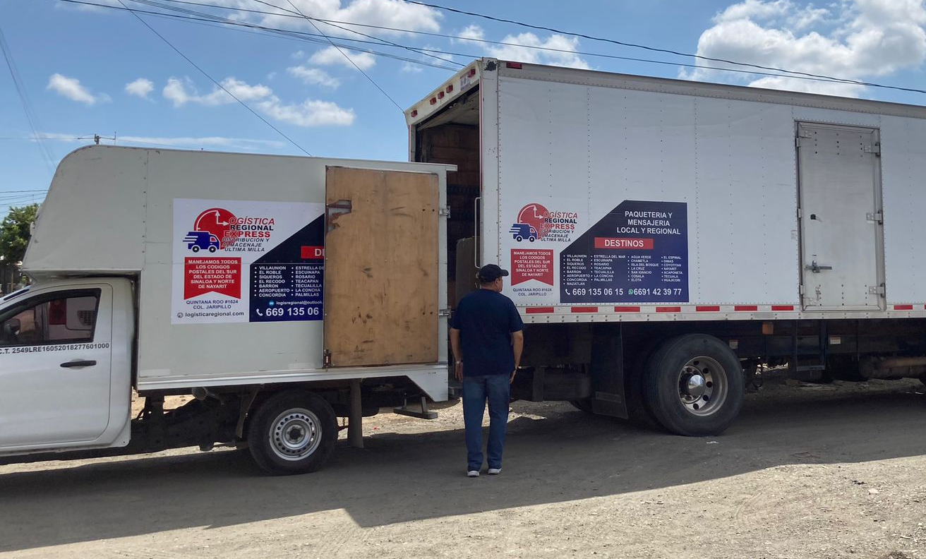 man in brown jacket and black pants sitting on white metal railings